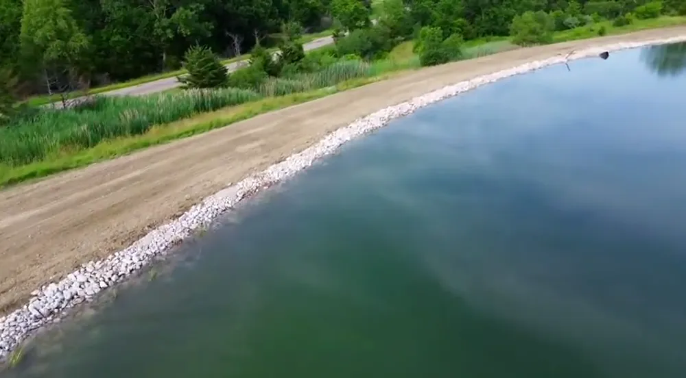 Aerial view of rock set along a rebuilt pond bank in central Illinois